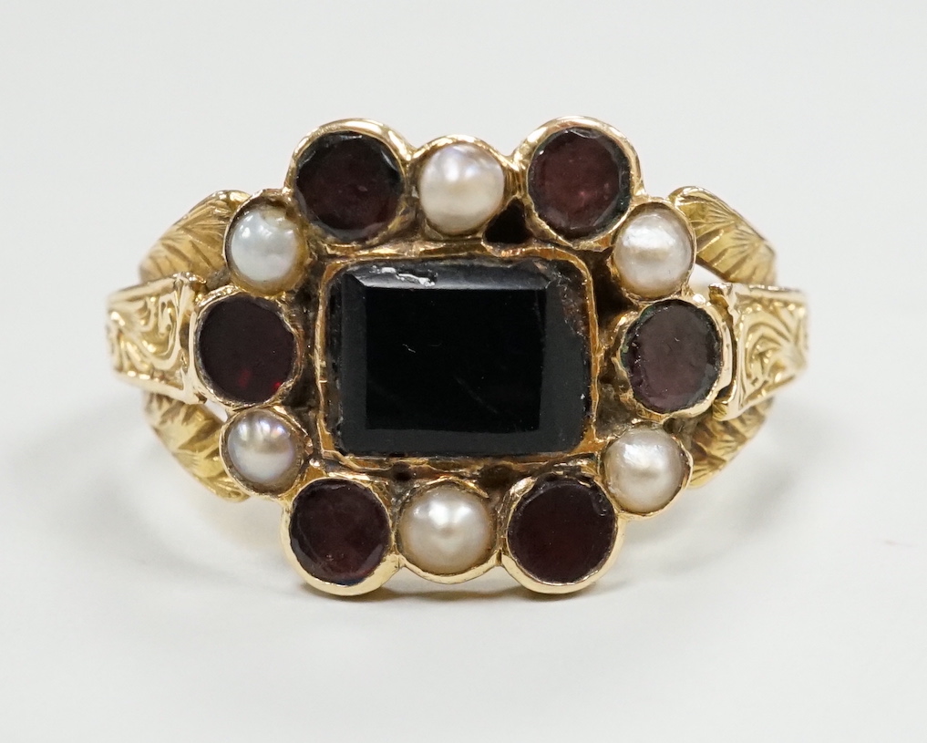 A George yellow metal, garnet and seed pearl cluster set mourning ring, with inscription dated 1799, size L, gross weight 2.7 grams.